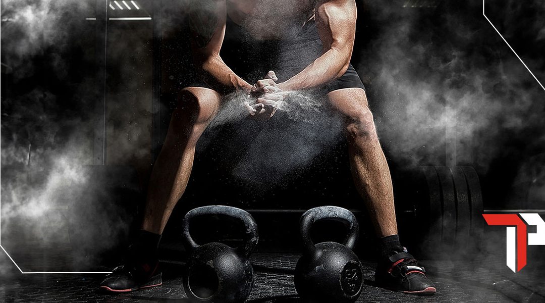 Man lifting kettlebells at the gym h
